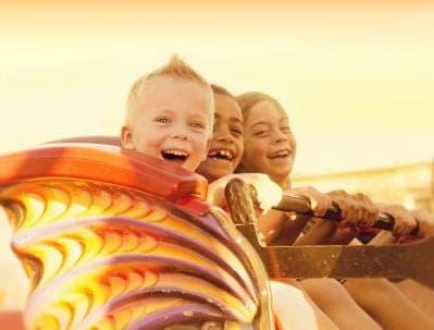 Kids on a roller coaster in the sunset