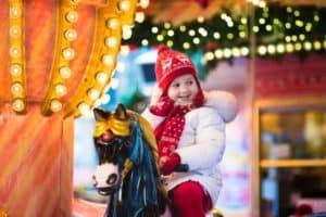 A happy toddler riding a carousel.