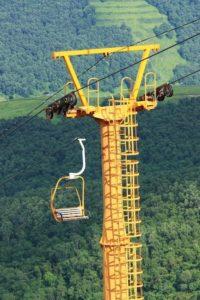 A yellow chair lift ride in the mountains.