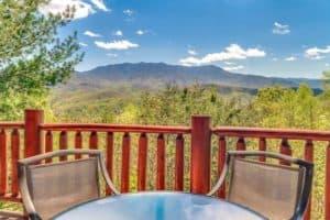 Chairs and a table on the deck of a vacation cabin with incredible views of the Smoky Mountains.