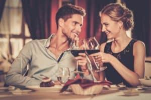 couple toasting wine glasses at dinner