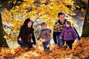 Happy family playing in the fall leaves.