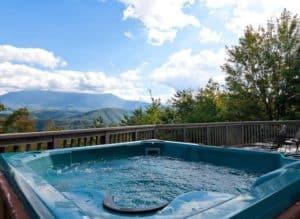 A hot tub on the deck of a cabin with beautiful views.