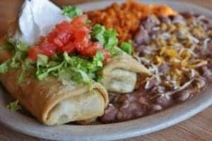 chimichanga with rice, beans, sour cream, lettuce, and tomatoes