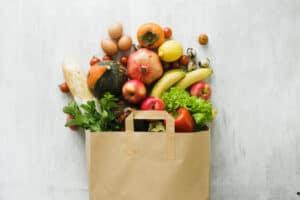 food spilling out of a brown paper bag onto a counter